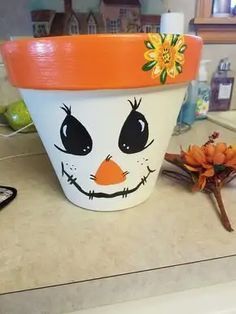 a flower pot with a face painted on it