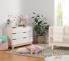 a baby's room with a crib, dresser and chair