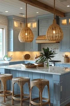 a kitchen with blue cabinets and wooden stools in front of an island that has three pendant lights hanging from the ceiling