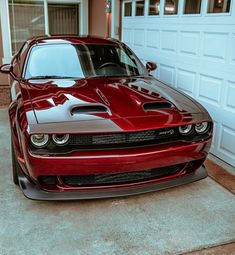 a red sports car parked in front of a garage