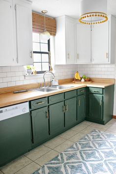 a kitchen with green cabinets and white tile flooring on the counter top, along with a blue rug