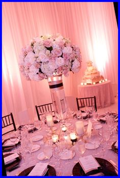 the centerpiece is surrounded by candles, plates and napkins for an elegant wedding reception