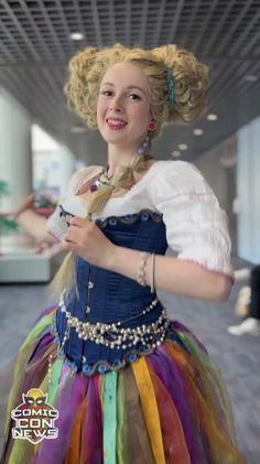 a woman in a colorful dress is posing for the camera