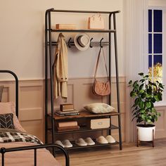 a room with a bed, shelf and shoes on the floor next to a potted plant