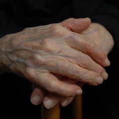 an old woman's hands resting on a cane