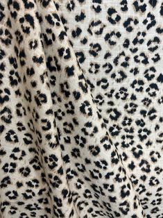 an animal print fabric with black spots on it's sides and the back side