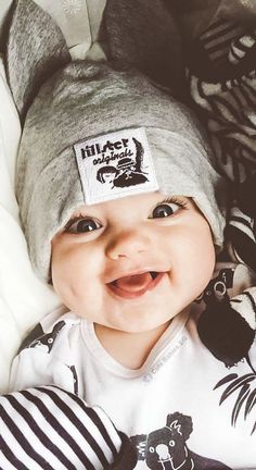 a baby wearing a hat and smiling for the camera