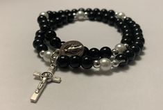 Beautiful stretchy rosary bracelets black beads with pearl Glory bes. St. Benedict crucifixes and Miraculous Metal are on it. Black Crucifix Rosary Bracelet As Gift, Bracelets Black, St Benedict, Rosary Bracelet, Black Beads, Rosary, Jewelry Bracelets, Beaded Bracelets, Bracelet