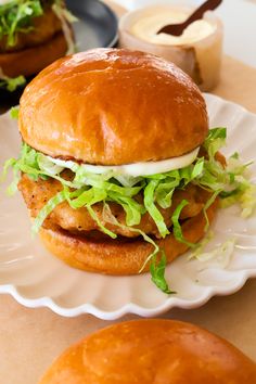 a chicken sandwich with lettuce and mayonnaise on a plate