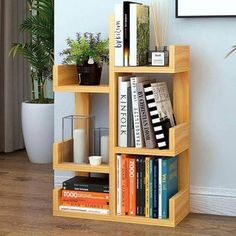 a bookshelf filled with lots of books next to a potted plant