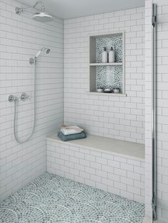 a white tiled bathroom with shelves and shower