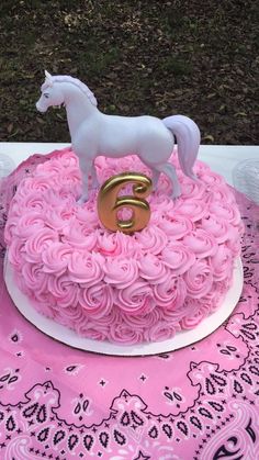 a pink cake with a white horse on top