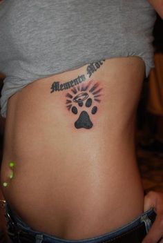 a woman's stomach with a dog paw tattoo on her belly and the words american pride written in black ink