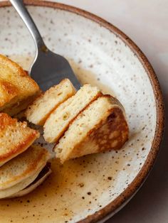 a plate that has some pancakes on it with a fork in it and is half eaten