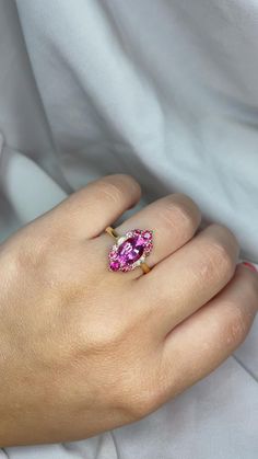 a woman's hand with a pink ring on it