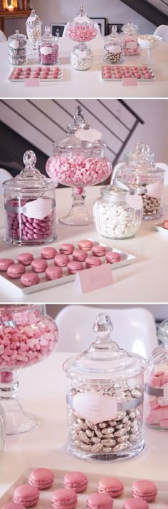 pink and white macaroons are on display in glass containers