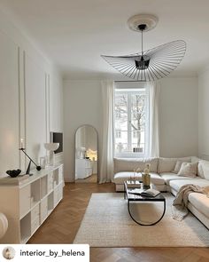 a living room filled with furniture and a large mirror on the wall above it's windows