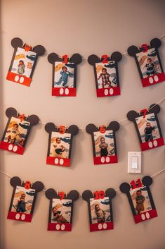 mickey mouse photo frames hanging on a wall with string lights attached to them and pictures pinned to the wall