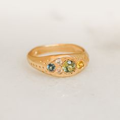 A brilliant array of color lights up this one of a kind signet cluster. Featuring reclaimed diamonds and ethically sourced sapphires set into a hand engraved band of recycled, solid 14k gold. Sizing: Ready to ship in size 6. Need a different size? Email lackadazee@gmail.com Materials & Measurements: Ethically sourced Montana Sapphires (3mm blue, 3mm yellow, 4mm green). Two reclaimed white diamonds (2.2mm). Hand engraved with line and dot pattern. Details: Crafted in Louisville, Kentucky using sustainable practices. There is a 4 week lead time on all orders, regardless of chosen shipping method. Care: All jewelry should be removed prior to sleeping, exercising, cleaning with heavy chemicals or any other strenuous/rough activity. Click HERE for additional care instructions. Shipping & Packag Heirloom Gold Cluster Ring With Sapphire, Heirloom Gold Sapphire Cluster Ring, Heirloom Sapphire Cluster Ring In Gold, Gold Sapphire Multi-stone Cluster Ring, Montana Sapphires, Color Lights, Green World, Montana Sapphire, Louisville Kentucky