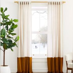 a living room with white walls and brown curtains