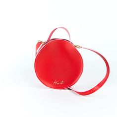 Circular leather handbag. Leather Bags With Round Handle For Gifts, Leather Bags With Adjustable Strap And Round Handle, Modern Satchel With Round Handle, Red Bag With Round Handle For Everyday Use, Chic Round Case Bag For Gift, Red Shoulder Bag With Round Handle For Daily Use, Leather Round Case Shoulder Bag As Gift, Travel Bag With Detachable Handle And Round Case, Round Case Bag With Detachable Handle