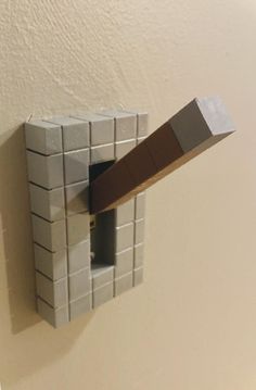 a piece of paper is stuck to the wall with a brick block in front of it