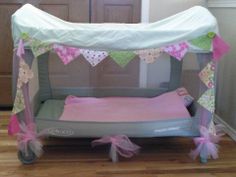 a baby crib in the middle of a room with pink and green decorations on it