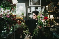 a woman arranging flowers in a flower shop