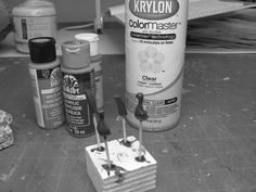 black and white photograph of paint, tools and other items on the floor in front of a table