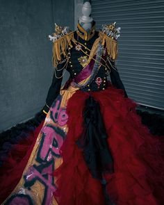 a mannequin dressed in a red and black dress with graffiti written on it