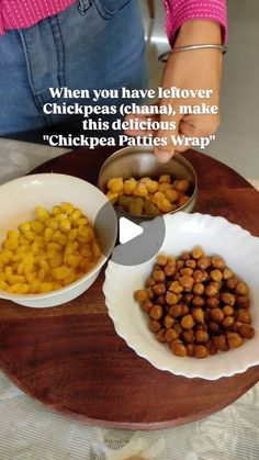 two bowls with chickpeas in them on a wooden tray next to a woman's hand