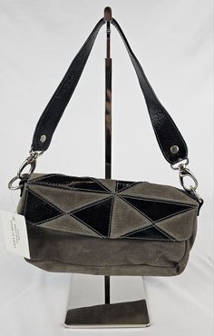 Elevate your style with this stunning Laura di Maggio shoulder bag. Crafted from a combination of patent leather, suede, and leather, this designer bag is a must-have for any fashion-forward woman. The geometric pattern and black and grey exterior color give it a unique look. With a 10.5" bag width, 6.5" bag height, and 3.5" bag depth, this small-sized bag is perfect for carrying your essentials. The snap closure and black leather/suede handle strap ensure that your belongings stay safe and secure. Whether you're going for a 90s vibe or a modern look, this bag is versatile enough to complement any outfit. Modern Suede Shoulder Bag With Magnetic Closure, Black Suede Bag For Formal Occasions, Modern Black Suede Bags, Black Suede Bag With Detachable Strap, Gray Leather Evening Shoulder Bag, Evening Gray Leather Shoulder Bag, Evening Gray Shoulder Bag With Gunmetal Hardware, Designer Gray Leather Shoulder Bag, Gray Leather Evening Bag