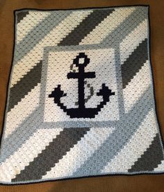 a crocheted blanket with an anchor on it