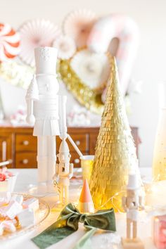 a table topped with lots of white and gold decorations