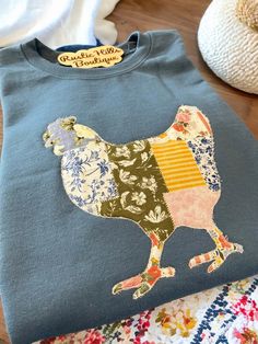 a blue shirt with a chicken on it