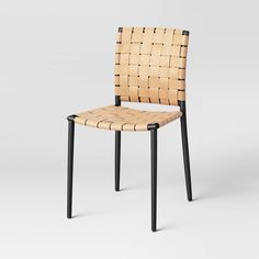 a chair made out of woven material with black legs and back rests against a white background