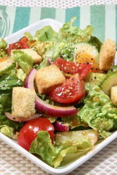 a salad with croutons, lettuce and tomatoes