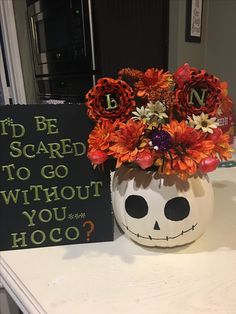 a decorated pumpkin with flowers in it sitting on a counter next to a sign that says, i'd be scared to go without you hoo?