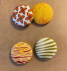 three fabric covered buttons sitting on top of a table