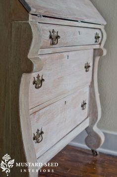 an old white dresser with knobs and handles