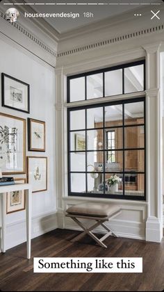 a living room filled with furniture and framed pictures on the wall next to a window