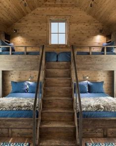 bunk beds in a cabin with stairs leading up to the top floor and bottom bed