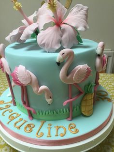 a blue cake with pink flamingos on it