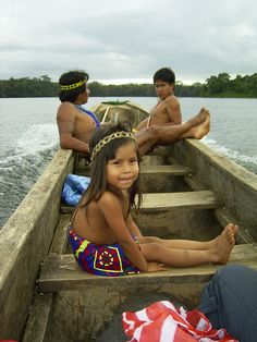 three people are sitting in the back of a boat with no one wearing a bathing suit