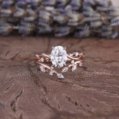 a close up of a ring on top of a wooden table next to some flowers