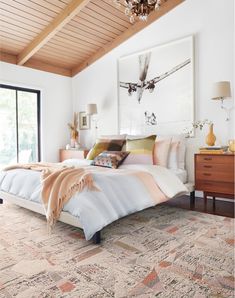 a bedroom with a bed, dressers and rug in it's center area