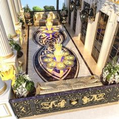 an elaborately decorated entrance way to a building with columns and flowers on the floor