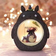 a totoro figurine with lights in the background