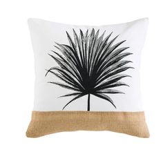 a black and white pillow with a palm tree on it