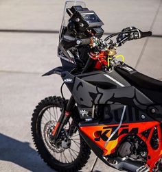 an orange and black dirt bike parked on the street